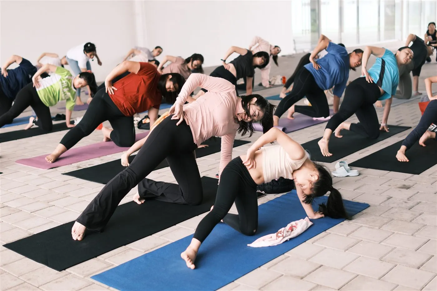 Mothers and daughters at a past outdoor yoga gathering